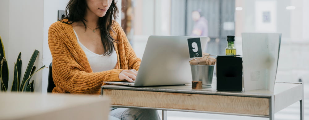 crop woman using laptop cafe