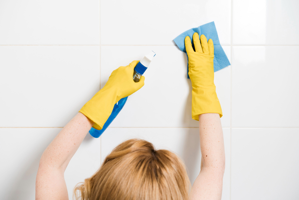 woman cleaning shower wall